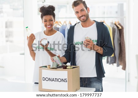 Portrait of a smiling young couple with donation box