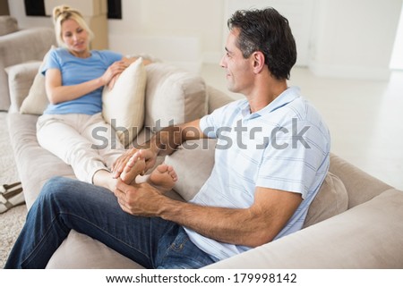 Relaxed man and woman sitting on sofa in the living room at home