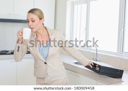 Businesswoman rushing out the door to work in the morning at home in the kitchen