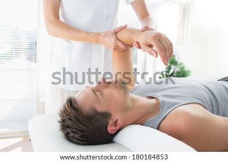 Young man receiving hand massage from therapist at health spa