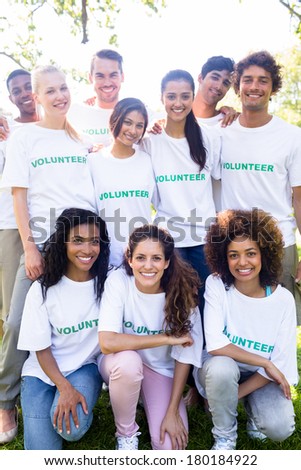 Group portrait of happy multiethnic volunteers together in park