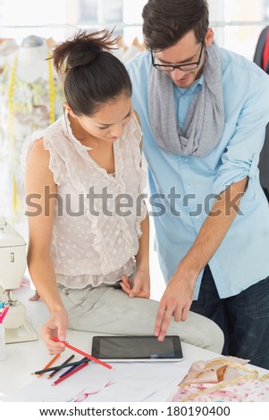 Male and female fashion designers using digital tablet in a studio