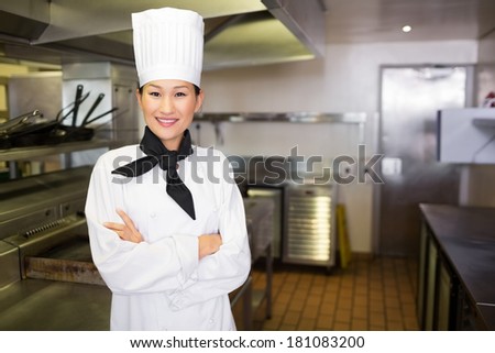 Portrait of a smiling female cook standing in the kitchen