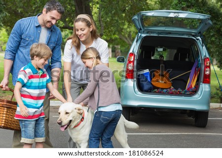 Portrait of a happy family of four with pet dog at picnic