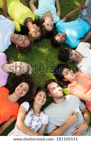 High angle view of a group of friends lying down in a circle at park