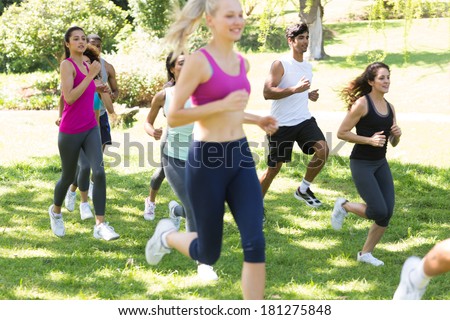 Group of athletes running on grassy land in park