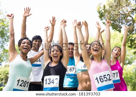 Group of marathon runners cheering after winning a race in the park