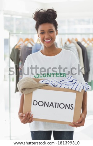 Portrait of a smiling young woman with clothes donation