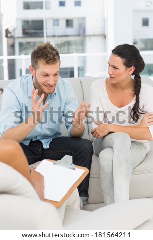 Unhappy man talking at couples therapy session in therapists office