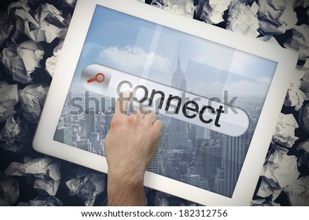 Hand touching the word connect on search bar on tablet screen on crumpled papers