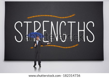 Businessman holding umbrella against the word strengths
