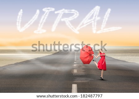 The word viral and beautiful woman posing with a broken umbrella against road leading out to the horizon