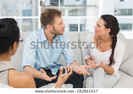 Unhappy couple arguing at therapy session in therapists office