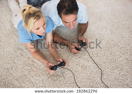 High angle view of a couple playing video games on area rug at home