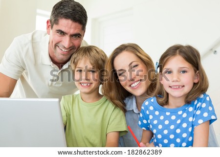 Portrait of happy family using laptop at home
