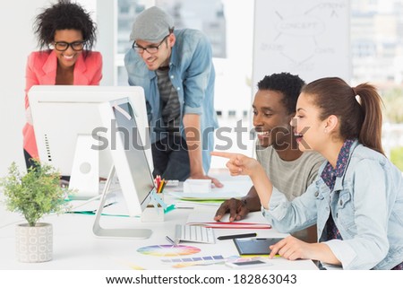 Group of casual artists working at desk in the creative office
