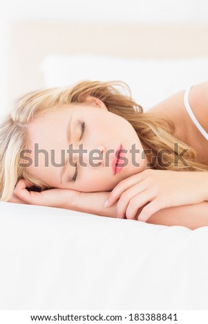 Natural young blonde lying on her bed sleeping at home in the bedroom