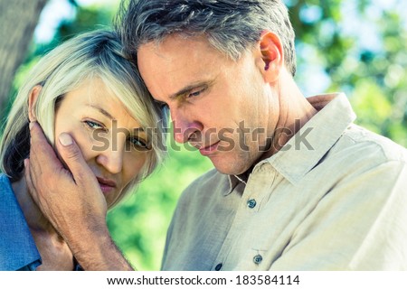 Closeup of loving man comforting woman in a park
