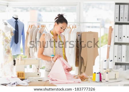 Concentrated young female fashion designer at work in a studio