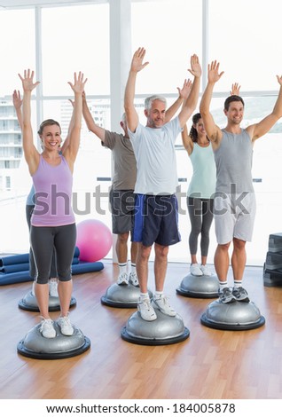 Full length portrait of smiling people doing power fitness exercise at yoga class