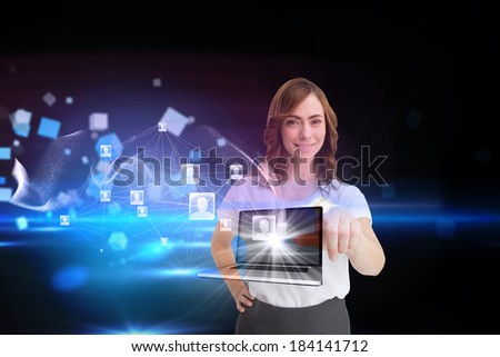 Digital composite of smiling businesswoman pointing to laptop and profiles behind