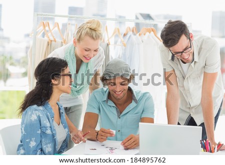 Group of fashion designers using laptop in a studio