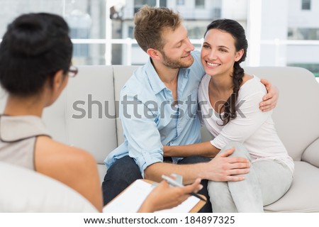 Happy couple reconciling at therapy session in therapists office