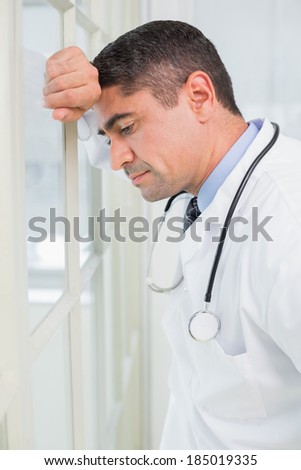 Side view of a thoughtful male doctor standing in the hospital