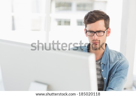 Concentrated young male artist using computer in the office