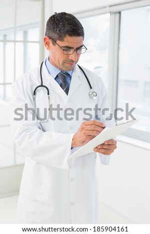 Concentrated male doctor writing reports in the hospital