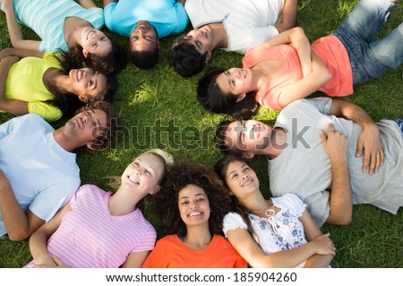 High angle view of multiethnic friends lying down in a circle at park