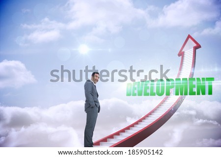 The word development and smiling businessman standing against red stairs arrow pointing up against sky