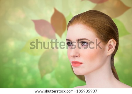 Beautiful redhead posing with hair tied against leaf pattern in green and brown