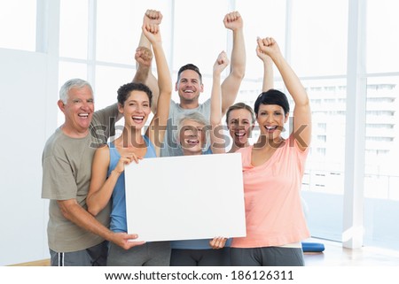 Portrait of happy fit people holding blank board in the yoga class