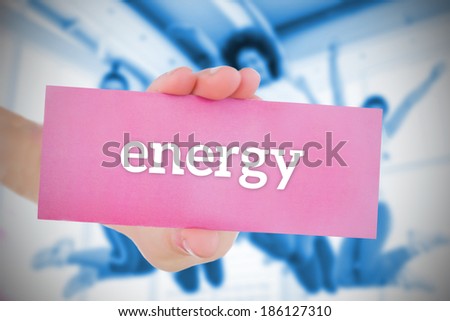 Woman holding pink card saying energy against class in gym