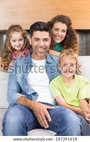 Happy family relaxing together smiling at camera at home in living room