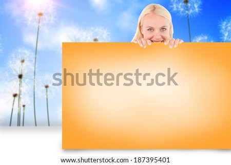 Composite image of pretty blonde showing orange card