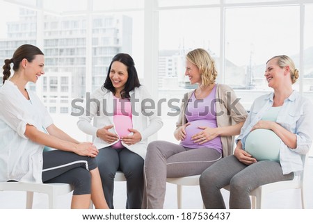 Happy pregnant women talking together at antenatal class at the hospital