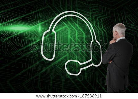 Composite image of headset with businessman looking against green and black circuit board