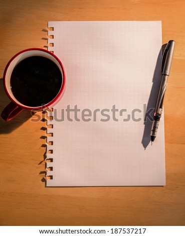 Overhead of graph paper coffee and pen on a desk