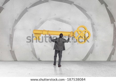 Businessman carrying large key with arms raised against sheet spiral on grey wall