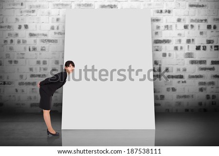 Composite image of serious businesswoman bending against white card