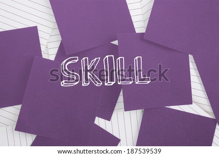 The word skill against purple paper strewn over notepad