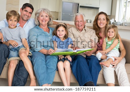 Portrait of happy multigeneration family with storybook at home