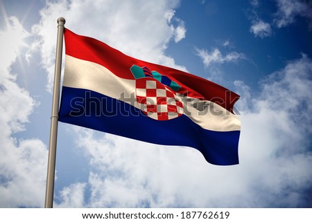 Croatia national flag against bright blue sky with clouds