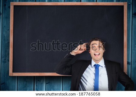 Thinking businessman scratching head against chalkboard on blue wooden planks