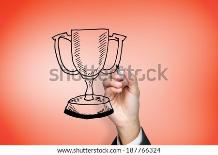 Composite image of businessman drawing winners cup against orange