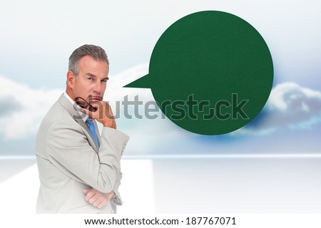 Thinking businessman with speech bubble against clouds in a room