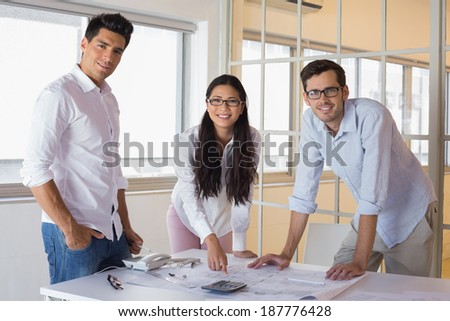 Casual architecture team working together smiling at camera in the office