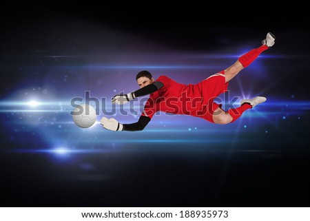 Fit goal keeper jumping up against black background with spark